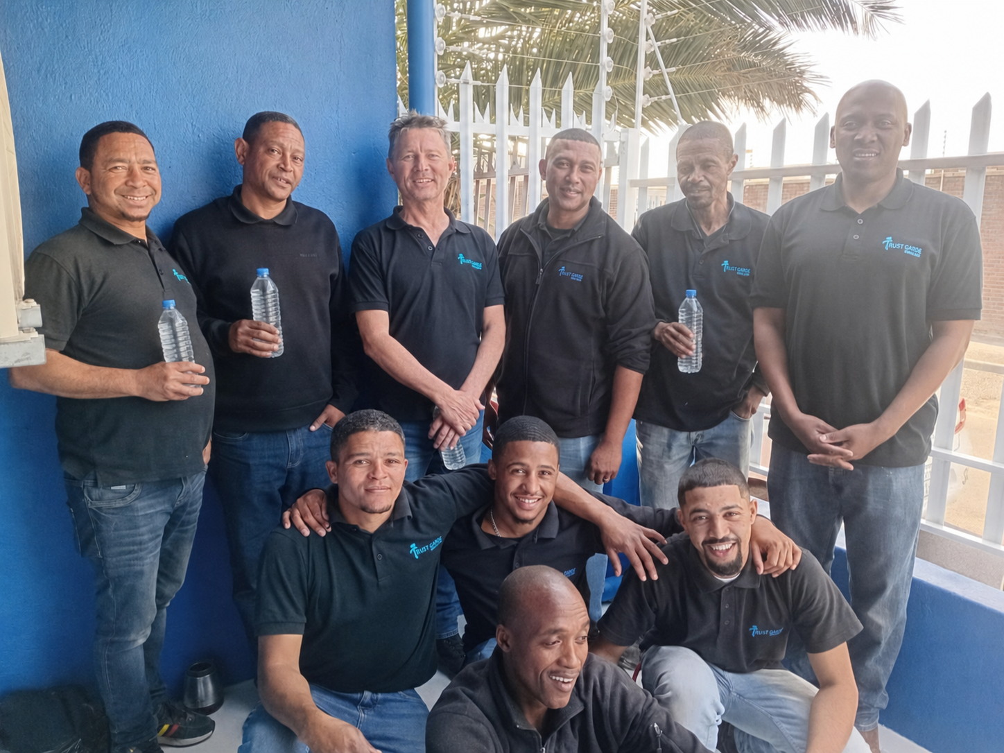 The Trust Garde team holding clear water bottles